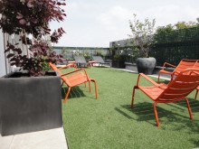 Aménagement terrasse parisienne avec mobilier orange Fermob