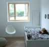 Chambre blanche avec lit pour enfant et radiateur mural