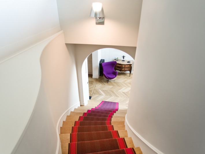 Grand escalier en bois avec tapis coloré