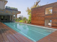 Piscine couloir de nage en partie recouverte par la maison