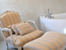 Salle de bains avec fauteuil et repose pied