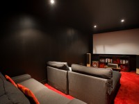 Salle de cinéma avec canapés en tissus gris et moquette rouge