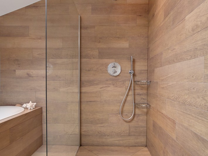 douche entièrement recouverte de planche en bois avec séparation en verre